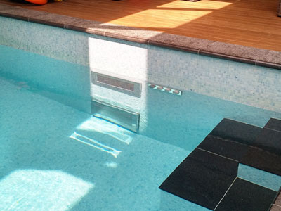 Private concrete swimming pool with counter current swimming machine.
